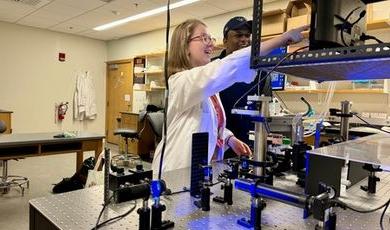 Helena works with optical tweezers in a lab alongside her professor.