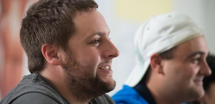 Two male students in class smiling